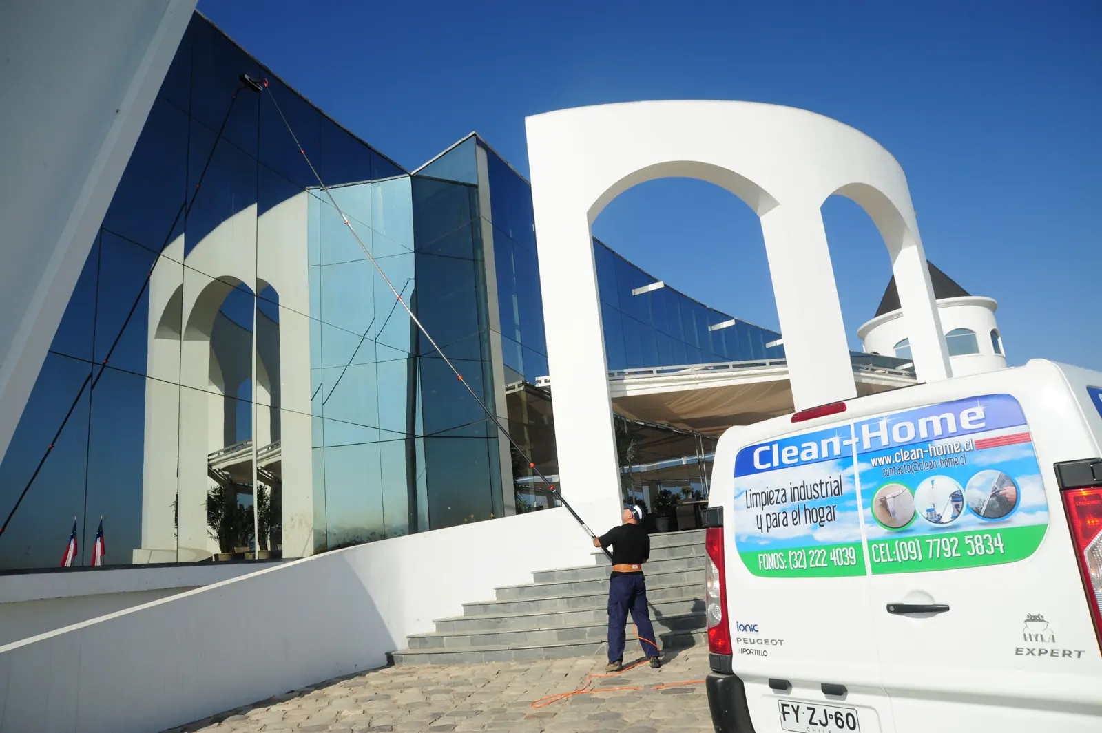 Camioneta de Clean-Home frente a un edificio con ventanales